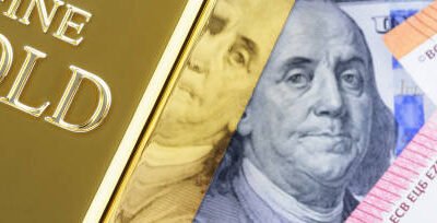Gold metal ingot bullion on the background of dollar and euro bills